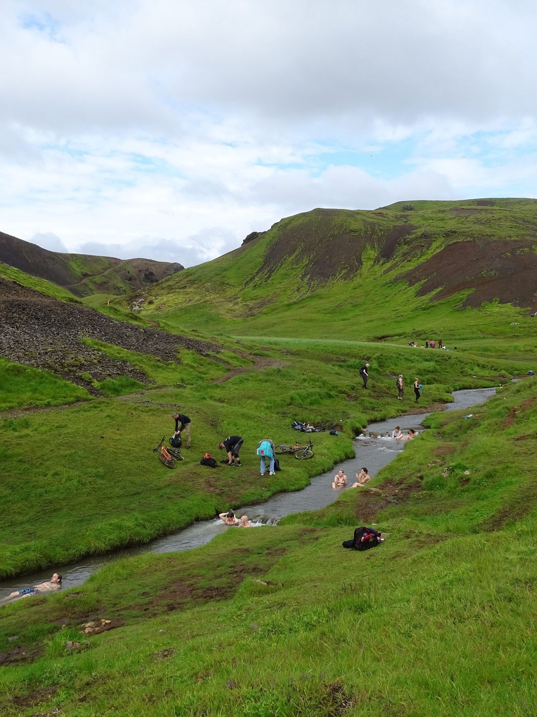 Bathers relaxing in the warm river at Reykjadalur, a free natural hot spring in South Iceland