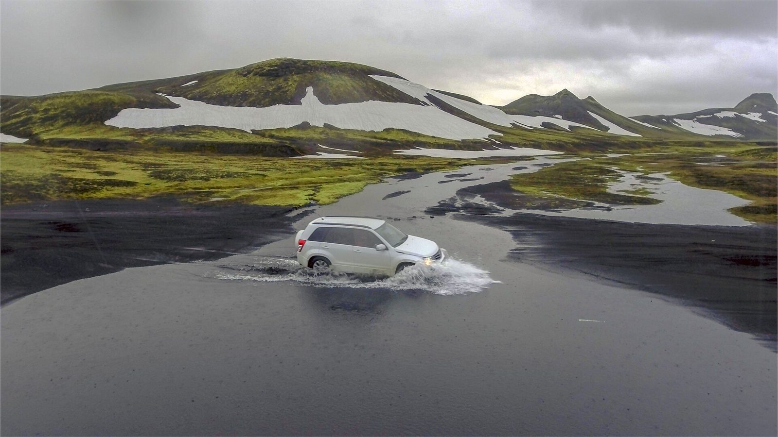 A 4×4 vehicle fording a river on the F208 highland road in Iceland